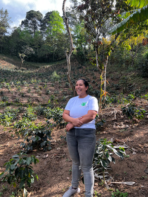 Woman coffee farmer standing with her coffee plants
